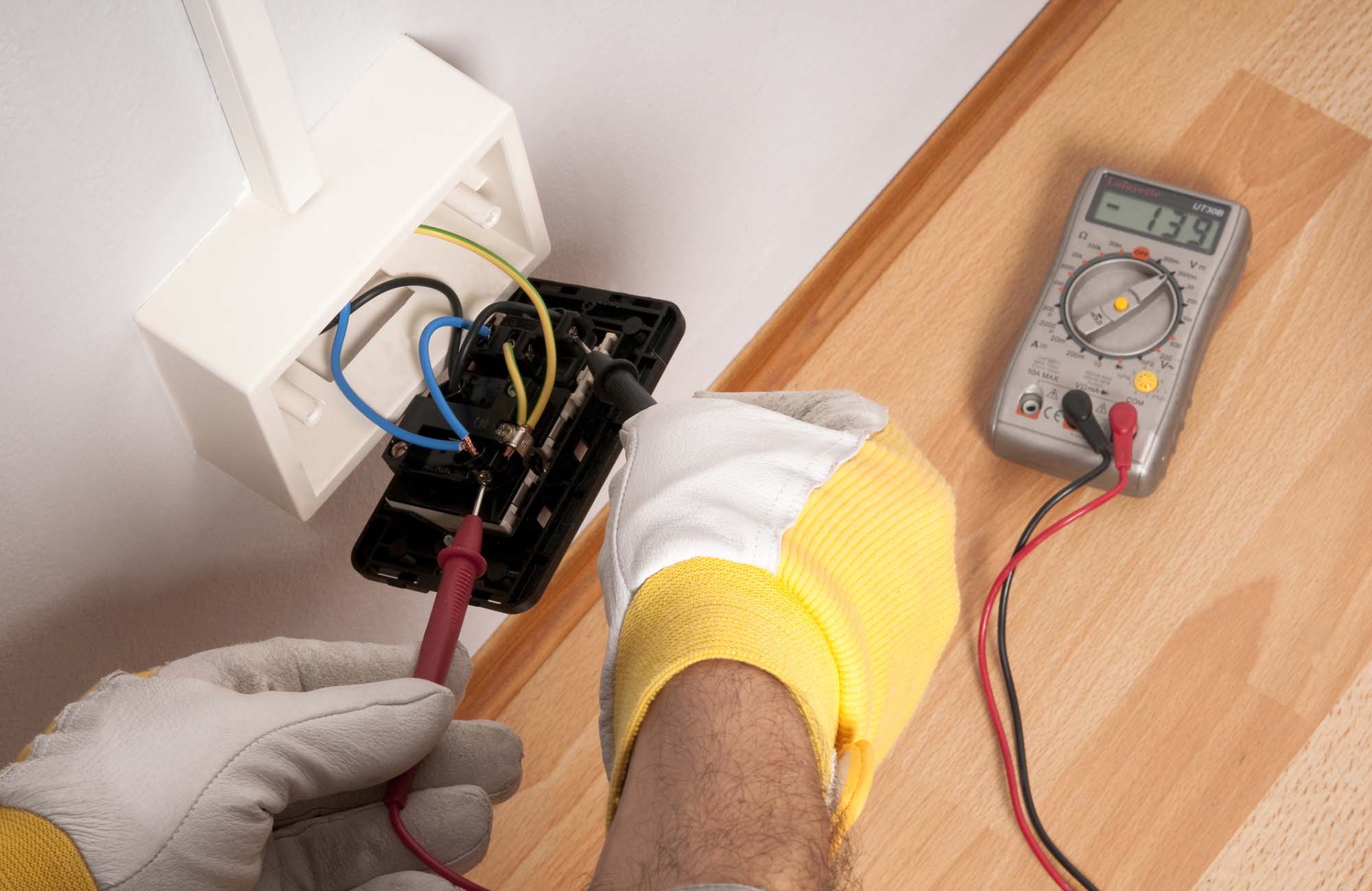 Electrician testing the volts of a UK plug