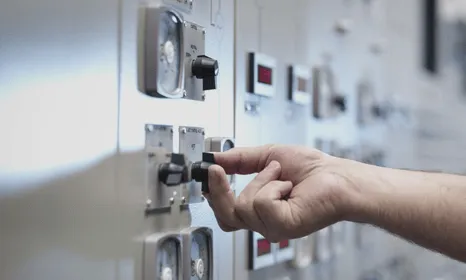 Hand switching knobs on a large electrical board